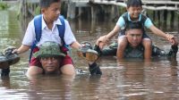 Anggota TNI Rela Terjang Banjir Kedalaman Seleher Demi Anak Sekolah